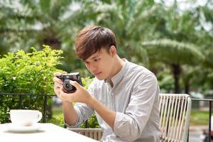 Male photographer taking picture in coffee shop photo