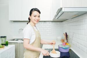 hermosa mujer cocinando algo en la cocina foto