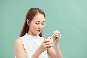 Diet Nutrition Concept. Pretty girl having yogurt, raisins and oatmeal photo