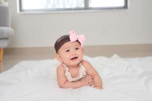 Beautiful asian baby lying on the floor photo