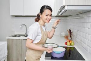 beautiful housewife cooking with ladle  in kitchen photo