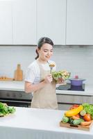 Young woman eating salad and holding a mixed photo