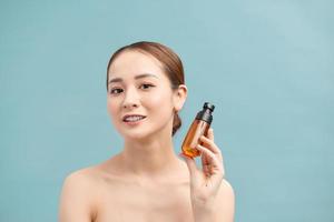smiling young woman showing skincare products photo