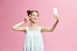 Photo of young beautiful smiling good mood take selfie show v-sign wear jumper on shoulders isolated on pink background