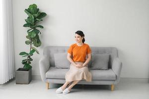 Young dreaming woman sitting on sofa at home. photo