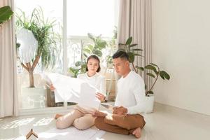 Young couple looking at blueprints of new home photo