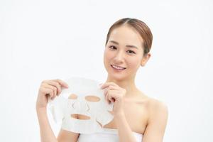 Portrait of young beautiful Asian woman holding face mask isolated on white background. photo