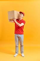 Portrait of a male delivery man holding a cargo box, background photo