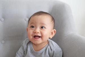 pretty baby sitting and smiling on the sofa photo