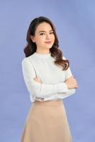 Portrait of successful business asian women with arms crossed and smile isolated over purple background photo