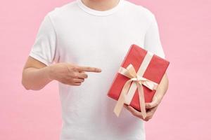 hombre con camiseta blanca sosteniendo cajas de regalo en las manos foto