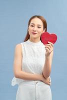 Red heart symbol of Valentines day smiling woman hold. photo