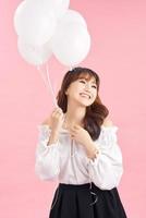 Portrait of smiling happy lady with air balloons on pink background. People concept photo
