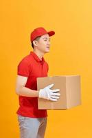 handsome young delivery man portrait isolated on yellow photo