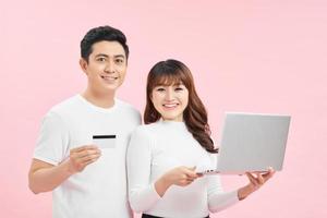 Smiling satisfied couple buying online with credit card at home photo