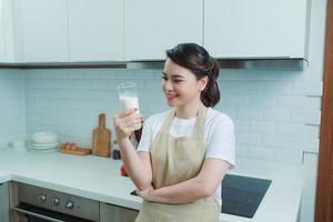 asian woman drink milk in the kitchen photo