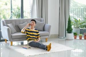 Man on the phone while sitting on his sofa against a white background photo