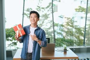 present box with gold ribbons standing on the table in hands photo