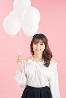 Beauty girl with white air balloons laughing, isolated on pink background photo