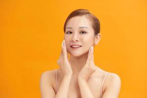 Young beautiful caucasian woman using a cotton pad to remove her make-up photo