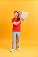 Delivery man holding parcel box isolated on white background photo