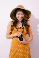 Happy young woman holding retro photo camera, isolated on pastel background