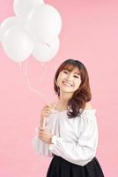 Cheerful young woman with balloons standing and laughing photo