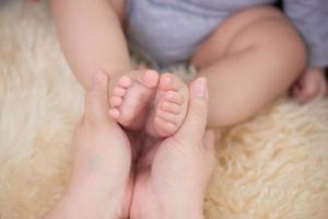 pies de bebé en manos de la madre foto