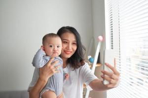 mujer con un bebé haciéndose un selfie foto