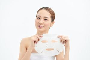 Portrait of young beautiful Asian woman holding face mask isolated on white background. photo