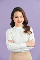 portrait of pretty asian girl smiling with arm crossed on purple background photo