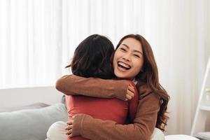 Young woman hugging her friend at home. photo