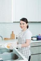 Asian lady wash a dish in kitchen room photo