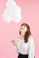 Portrait of asian appearance stand with pink air balloons, raised hands up. Happy photo