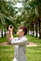 Young attractive man, a photographer, taking photographs in an urban area photo