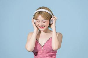 Full length body size view of a pretty cheerful girl listening song having fun dancing chill isolated on blue pastel background photo