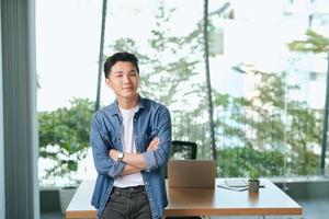 confident businessman standing  in modern office photo