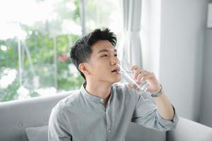 Handsome man drinking a fresh glass of water photo