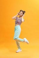 Image of happy young woman make winner gesture over yellow background. Look at camera. photo