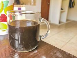 Taza de cristal de café negro de México sobre fondo de madera. foto