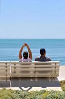 Happy young couple sitting on the beach photo