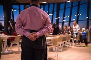 Sweden, 2022 - waiter standing with hands behind his back photo