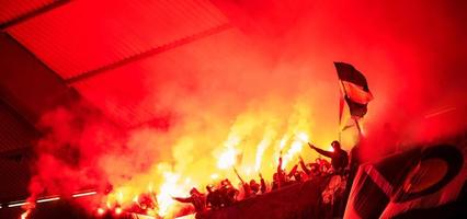 croacia, 2022 - vándalos de fútbol con máscara sosteniendo antorchas en llamas foto