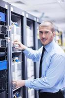 young it engineer in datacenter server room photo