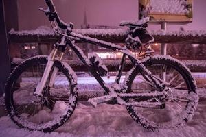 parked bicycle covered by snow photo