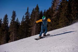 snowboarder running down the slope and ride free style photo