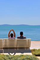 Happy young couple sitting on the beach photo