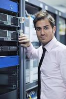 young it engineer in datacenter server room photo