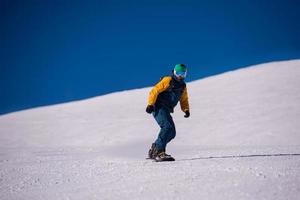 snowboarder running down the slope and ride free style photo