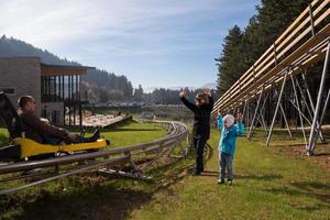 Sweden, 2022 - Happy family driving on alpine coaster photo